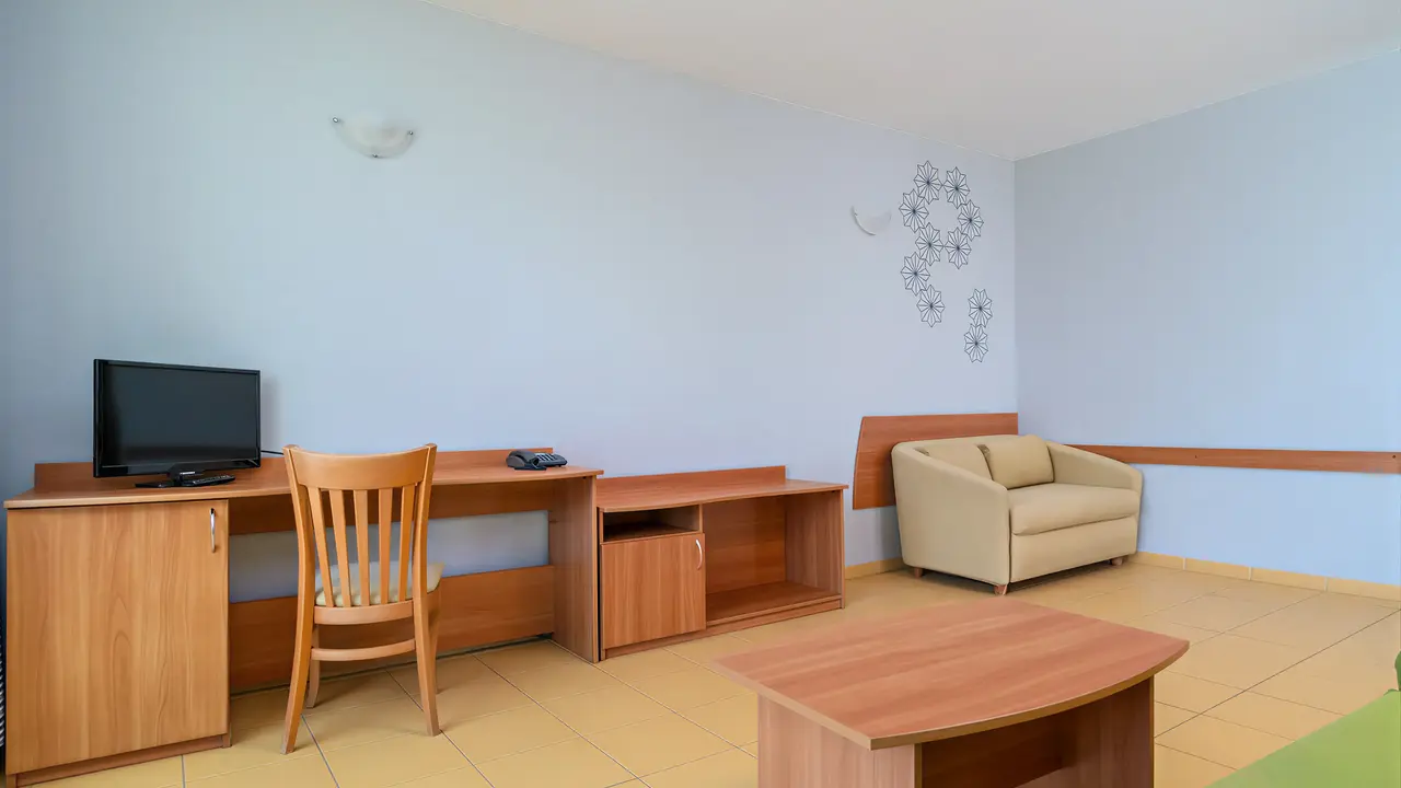 Wnętrze pokoju w MPM Kalina Garden z biurkiem i fotelem