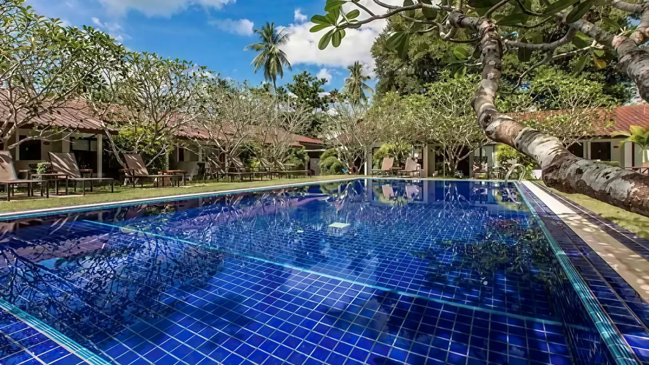 Niebieski basen w ogrodzie Nai Yang Beach Resort