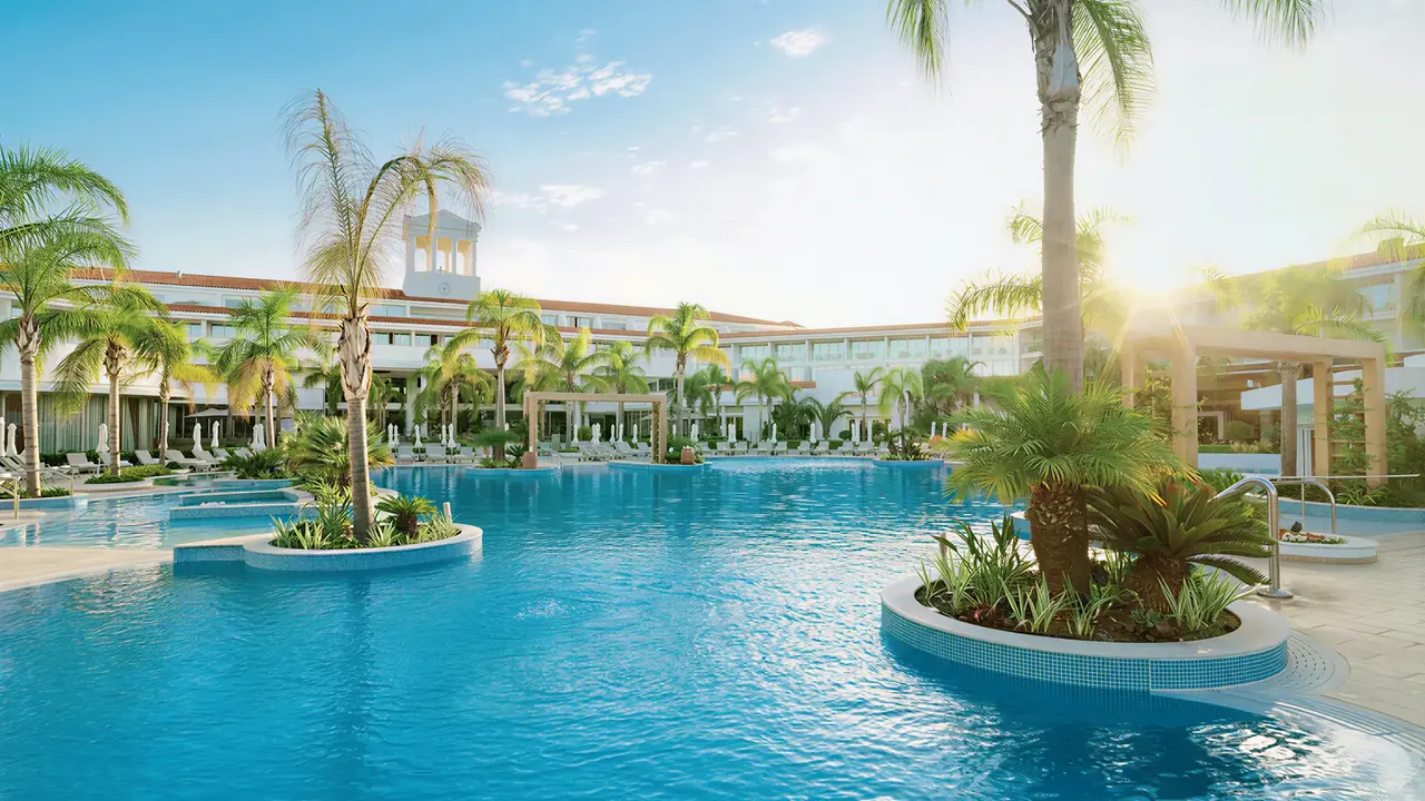 Basen z palmami w hotelu Olympic Lagoon Resort Paphos