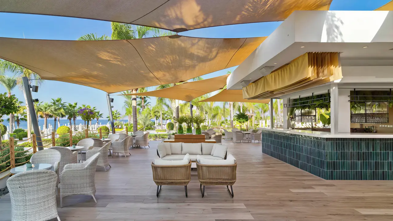 Bar zewnętrzny z wygodnymi meblami w Olympic Lagoon Resort Paphos