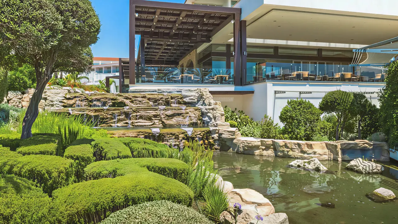 Ogród z kaskadą wody w Olympic Lagoon Resort Paphos