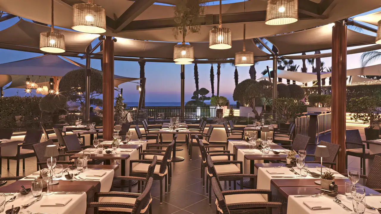 Elegancka restauracja w Olympic Lagoon Resort Paphos z widokiem na morze