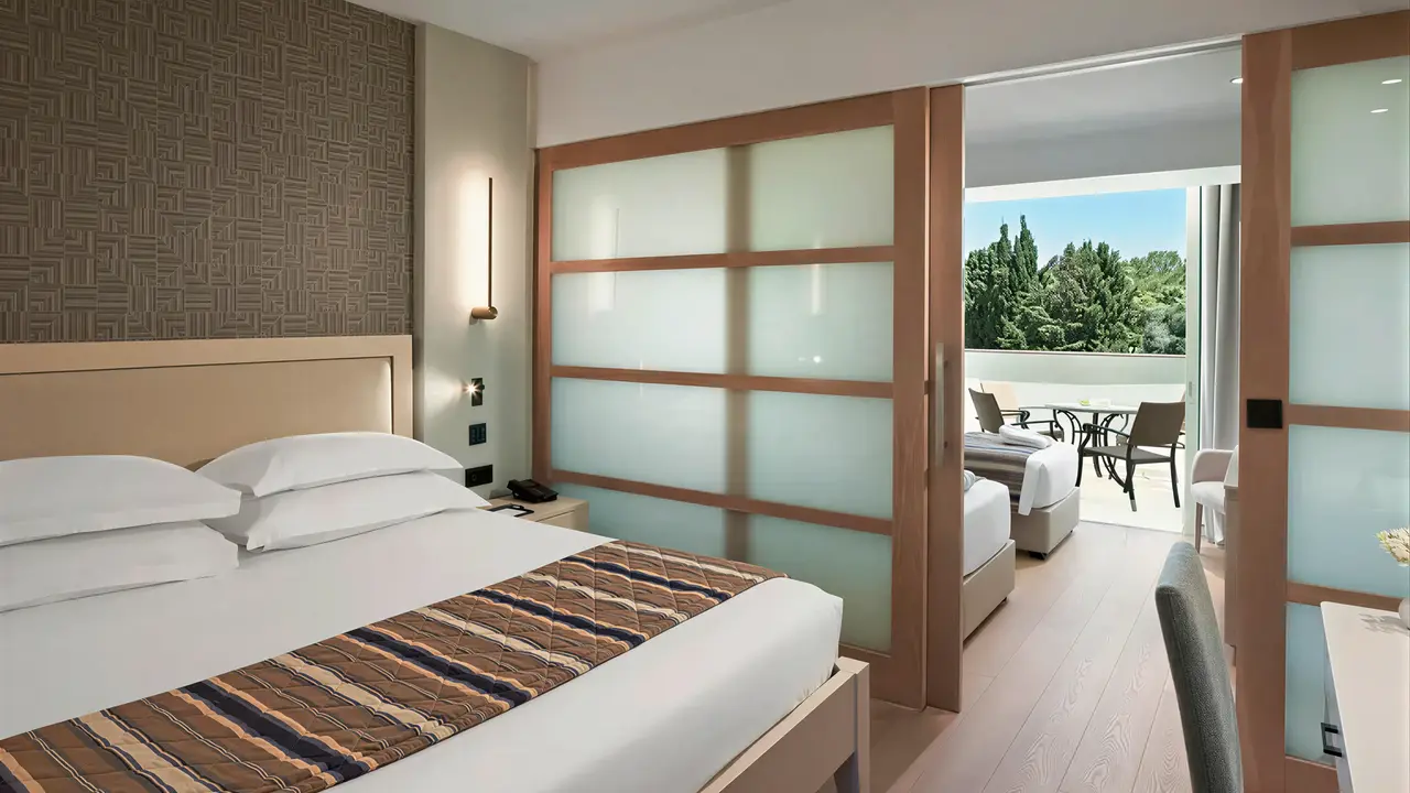 Sypialnia z tarasem w Olympic Lagoon Resort Paphos