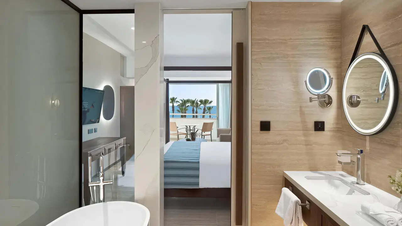 Nowoczesna łazienka w Olympic Lagoon Resort Paphos z widokiem na sypialnię