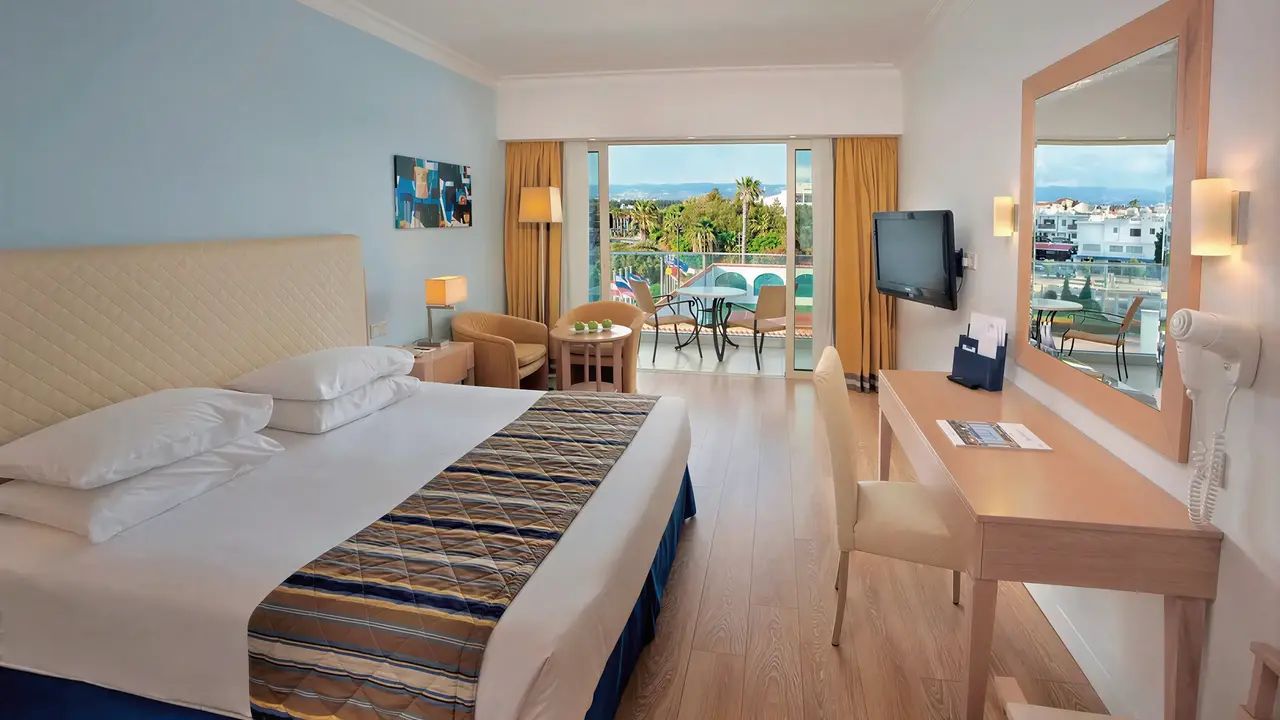 Sypialnia z widokiem na balkon w Olympic Lagoon Resort Paphos