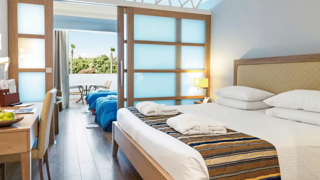 Przytulna sypialnia w Olympic Lagoon Resort Paphos z widokiem na taras