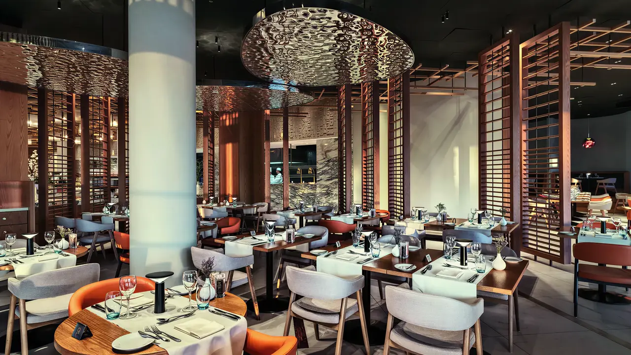 Elegancka restauracja w Olympic Lagoon Resort Paphos z ustawionymi stolikami