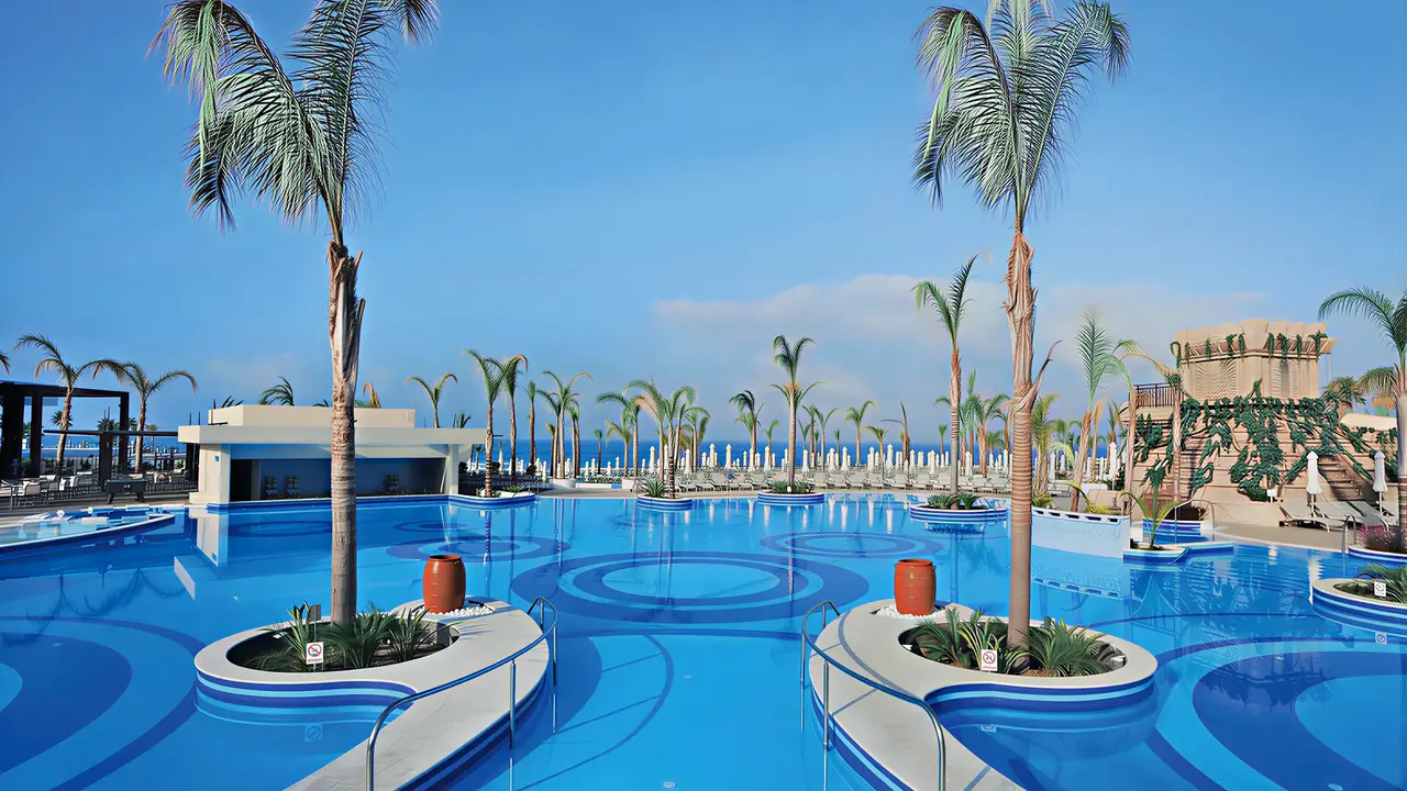 Basen z palmami w Olympic Lagoon Resort Paphos