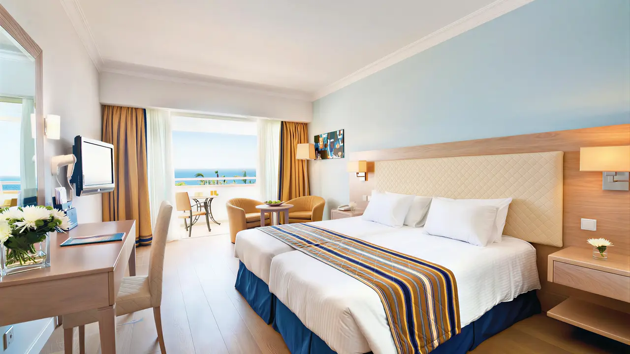 Pokój z łóżkami i balkonem w Olympic Lagoon Resort Paphos