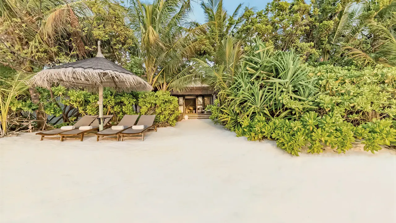 Leżaki i parasol na plaży w Ozen Life Maadhoo