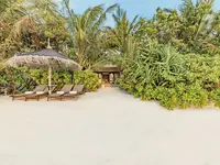 Leżaki i parasol na plaży w Ozen Life Maadhoo