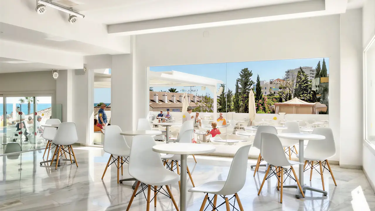 Jasna restauracja w Palia La Roca z białymi stolikami