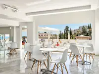 Jasna restauracja w Palia La Roca z białymi stolikami