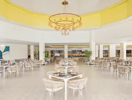 Jasna restauracja w Pickalbatros Jungle Aqua Park Resort Neverland z ustawionymi stolikami