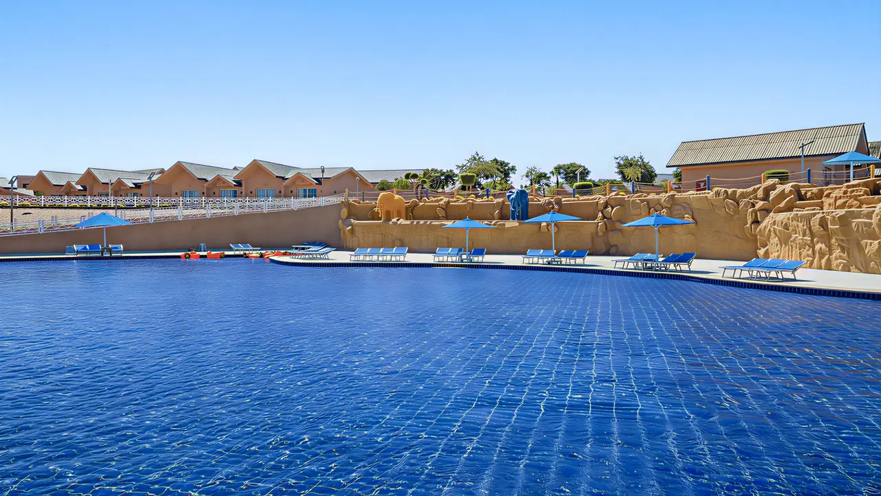 Basen z leżakami i parasolami w Pickalbatros Jungle Aqua Park Resort Neverland