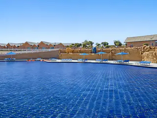Basen z leżakami i parasolami w Pickalbatros Jungle Aqua Park Resort Neverland