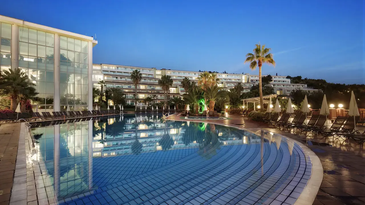 Basen zewnętrzny w hotelu Pine Bay Holiday Resort o zmierzchu