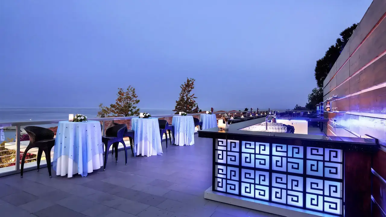 Strefa cocktail reception w Pine Bay Holiday Resort z wysokimi stolikami