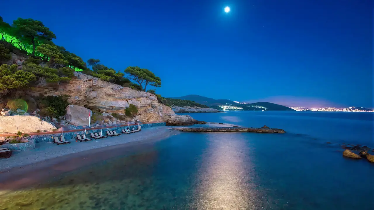 Nocna plaża w Pine Bay Holiday Resort z leżakami