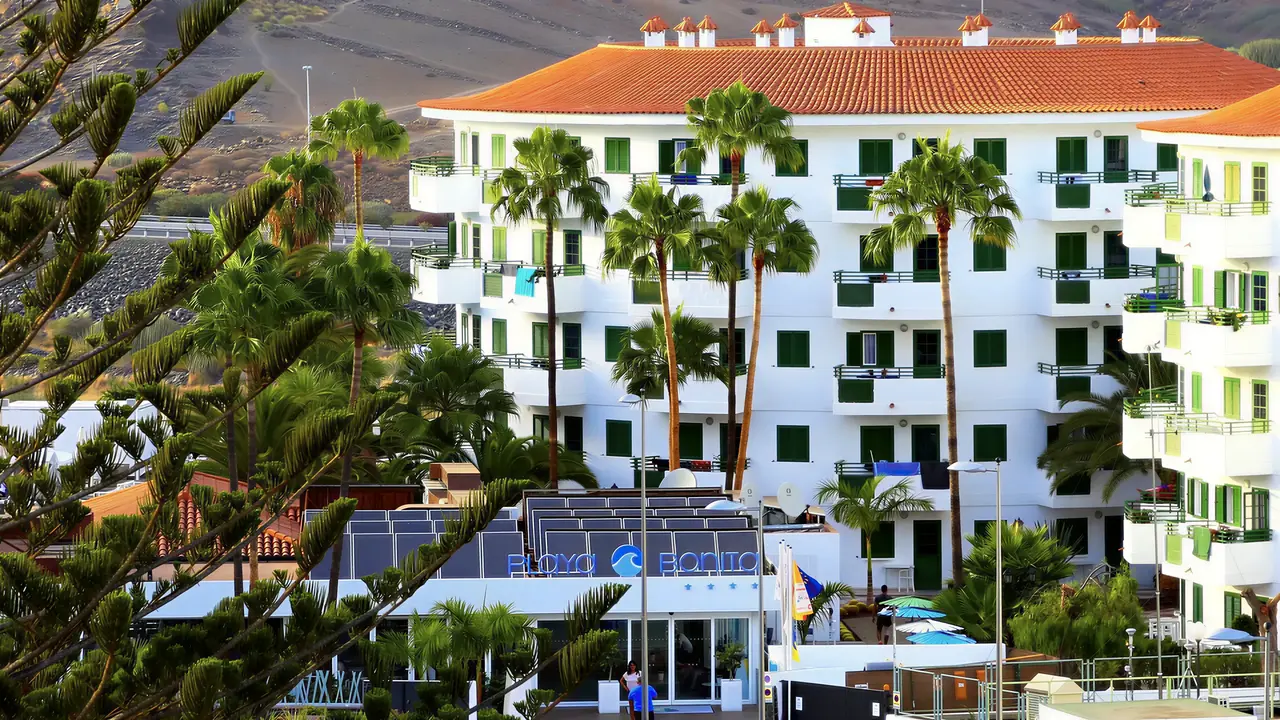 Biały budynek hotelu Playa Bonita z palmami