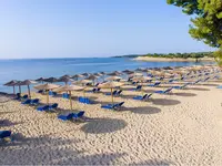 Plaża z leżakami i parasolami w Poseidon Sea Resort