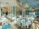 Jasna restauracja w Quattro Beach Spa z białymi stolikami