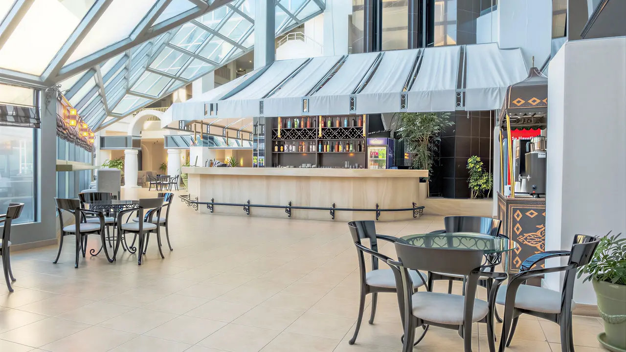 Bar w hotelu Queens Park Resort Goynuk z eleganckimi stolikami