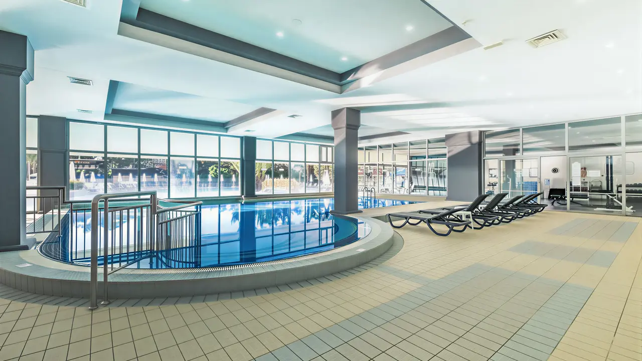 Kryty basen w Queens Park Resort Goynuk z leżakami