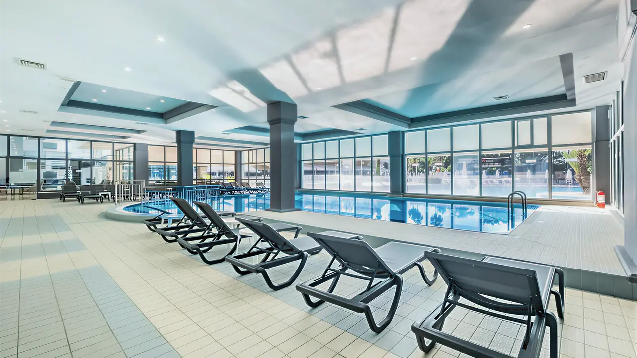 Kryty basen z leżakami w Queens Park Resort Goynuk