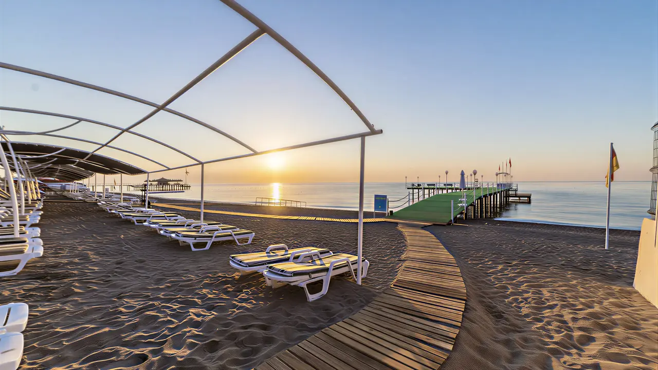 Plaża z leżakami w Queens Park Resort Goynuk o zachodzie słońca