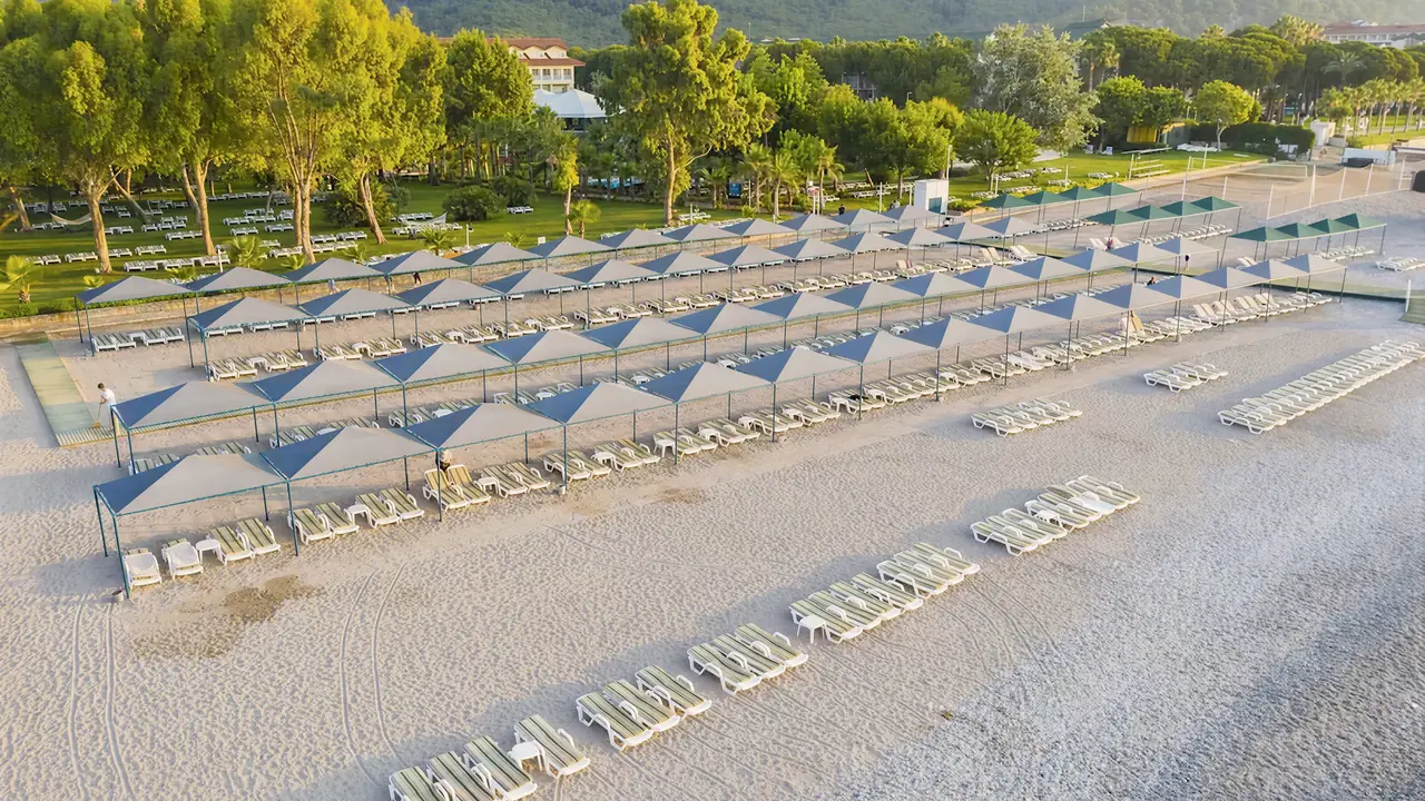 Leżaki i parasole na plaży w Queens Park Resort Goynuk