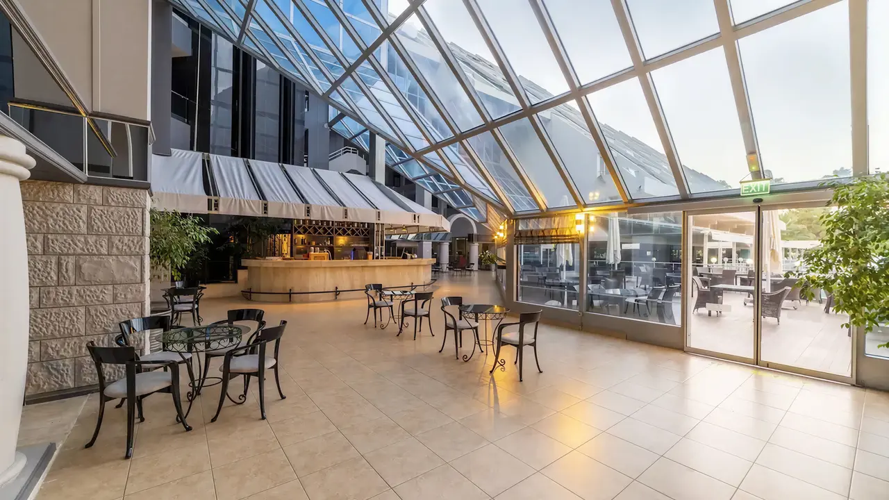 Bar z wysokim szklanym sufitem w Queens Park Resort Goynuk