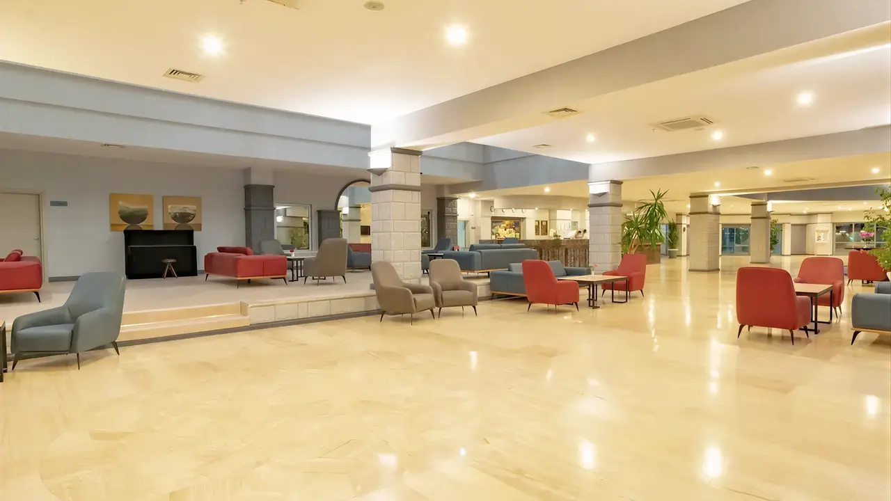 Wnętrze lobby z wygodnymi fotelami w Queens Park Resort Goynuk
