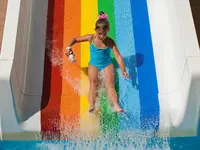 Dziecko zjeżdża na tęczowej zjeżdżalni w Ramira Beach