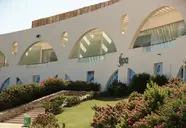 Elewacja budynku Retac Qunay Dahab Resort & Spa z zielenią i kwiatami