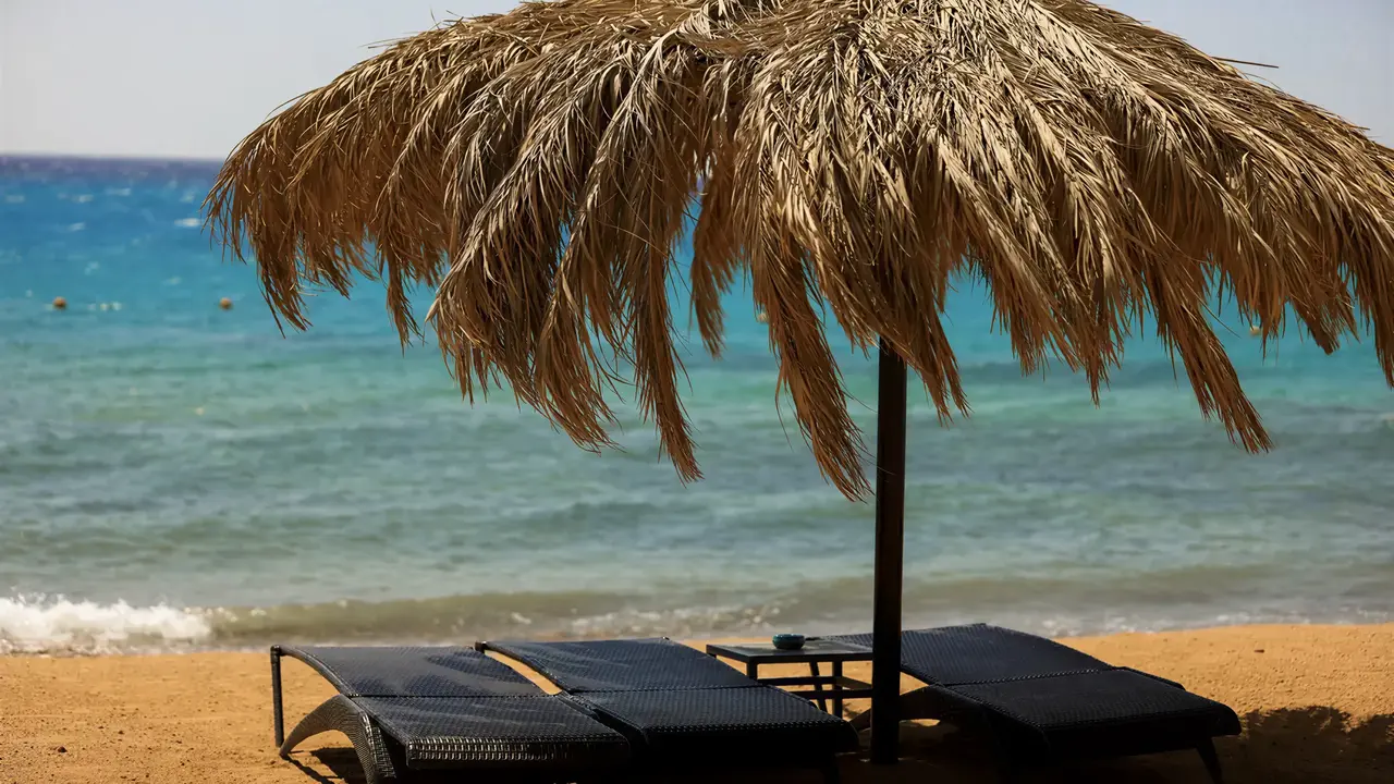 Leżaki pod parasolem na plaży w Retac Qunay Dahab Resort & Spa