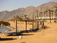 Leżaki i parasole na plaży w Retac Qunay Dahab Resort & Spa