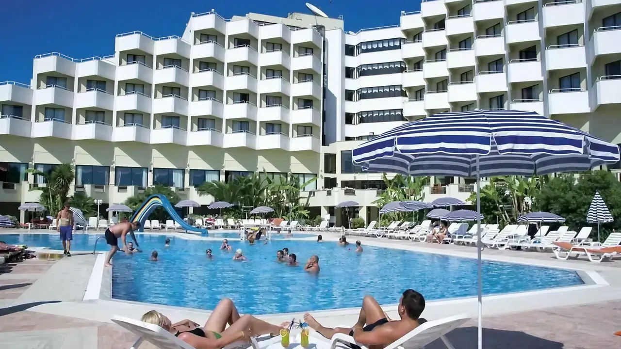 Basen z leżakami i parasolem w Richmond Ephesus Resort