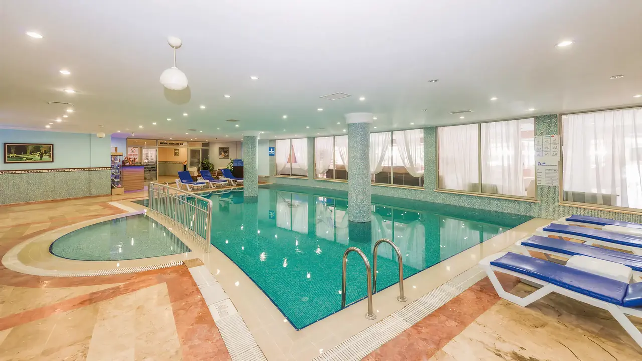 Kryty basen w hotelu Royal Atlantis Beach z leżakami