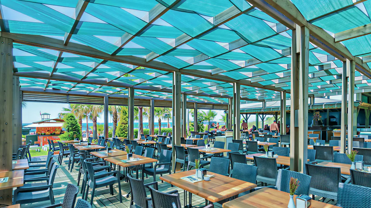 Restauracja w Royal Atlantis Beach z drewnianymi stołami
