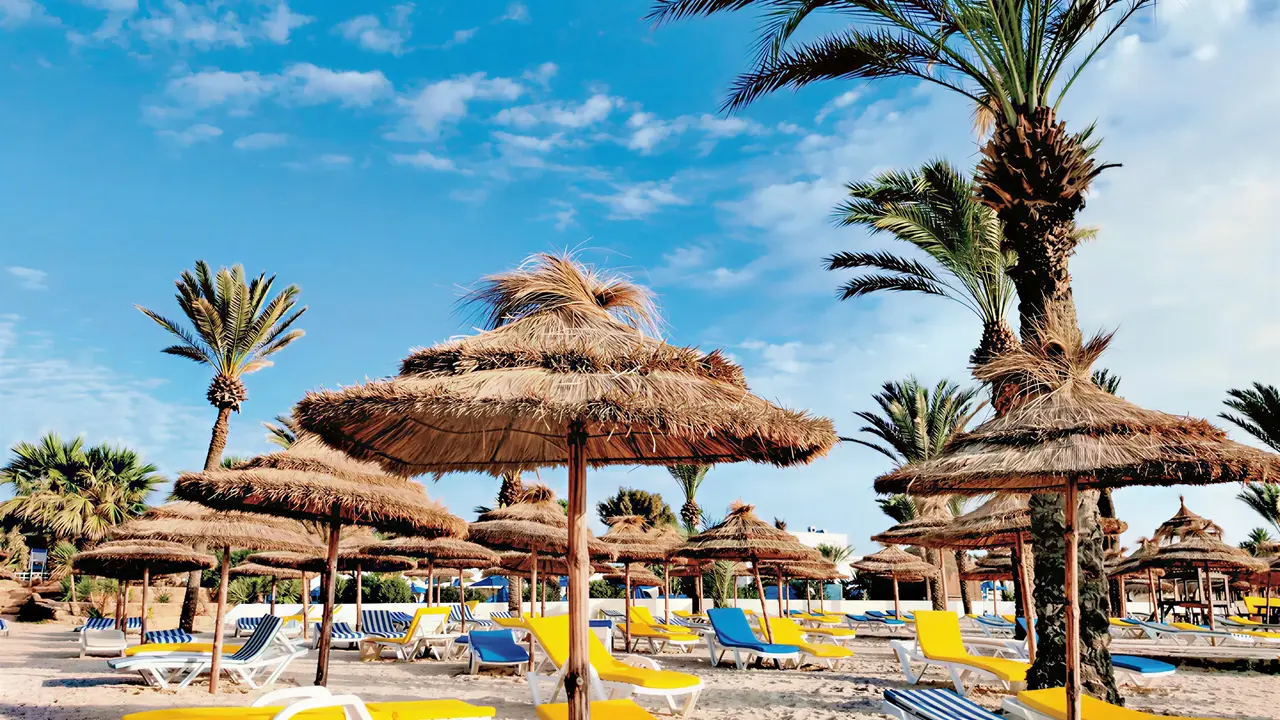 Leżaki i słomiane parasole na plaży Royal Karthago