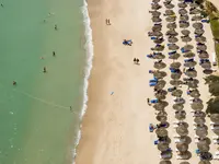 Plaża z parasolami i leżakami w Royal Tulip Taj Sultan 