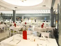 Elegancka restauracja w Royal Tulip Taj Sultan  z białymi obrusami