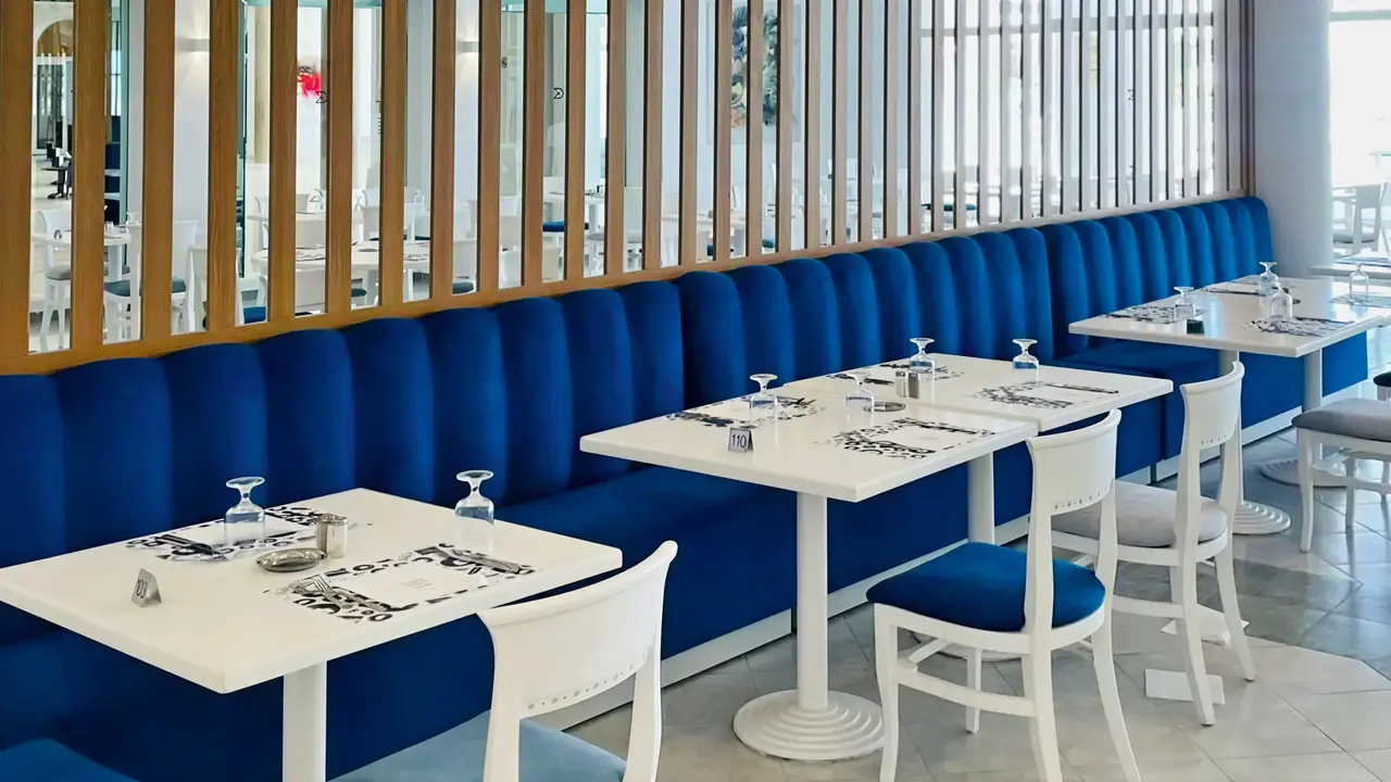 Restauracja w hotelu Royal Tulip Taj Sultan  z białymi stolikami