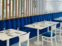 Restauracja w hotelu Royal Tulip Taj Sultan  z białymi stolikami