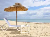 Leżak i parasol na plaży w Royal Tulip Taj Sultan 
