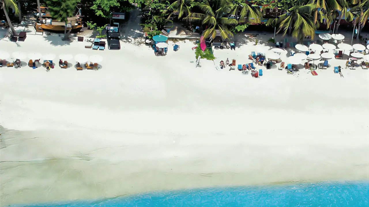 Piaszczysta plaża z parasolami w Sai Kaew