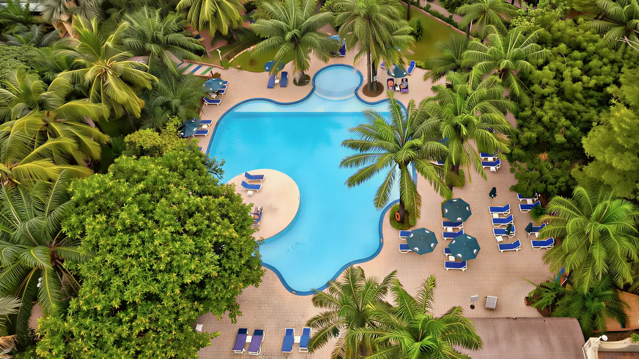 Basen z leżakami i palmami w Senegambia Beach