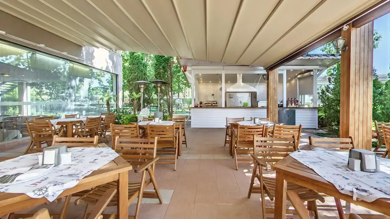 Restauracja w Sentido Bellevue Beach  z drewnianymi stołami