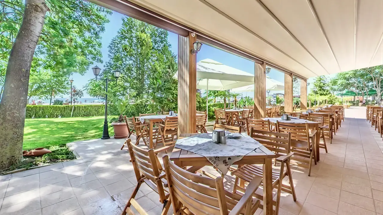 Taras restauracyjny z drewnianymi meblami w Sentido Bellevue Beach 